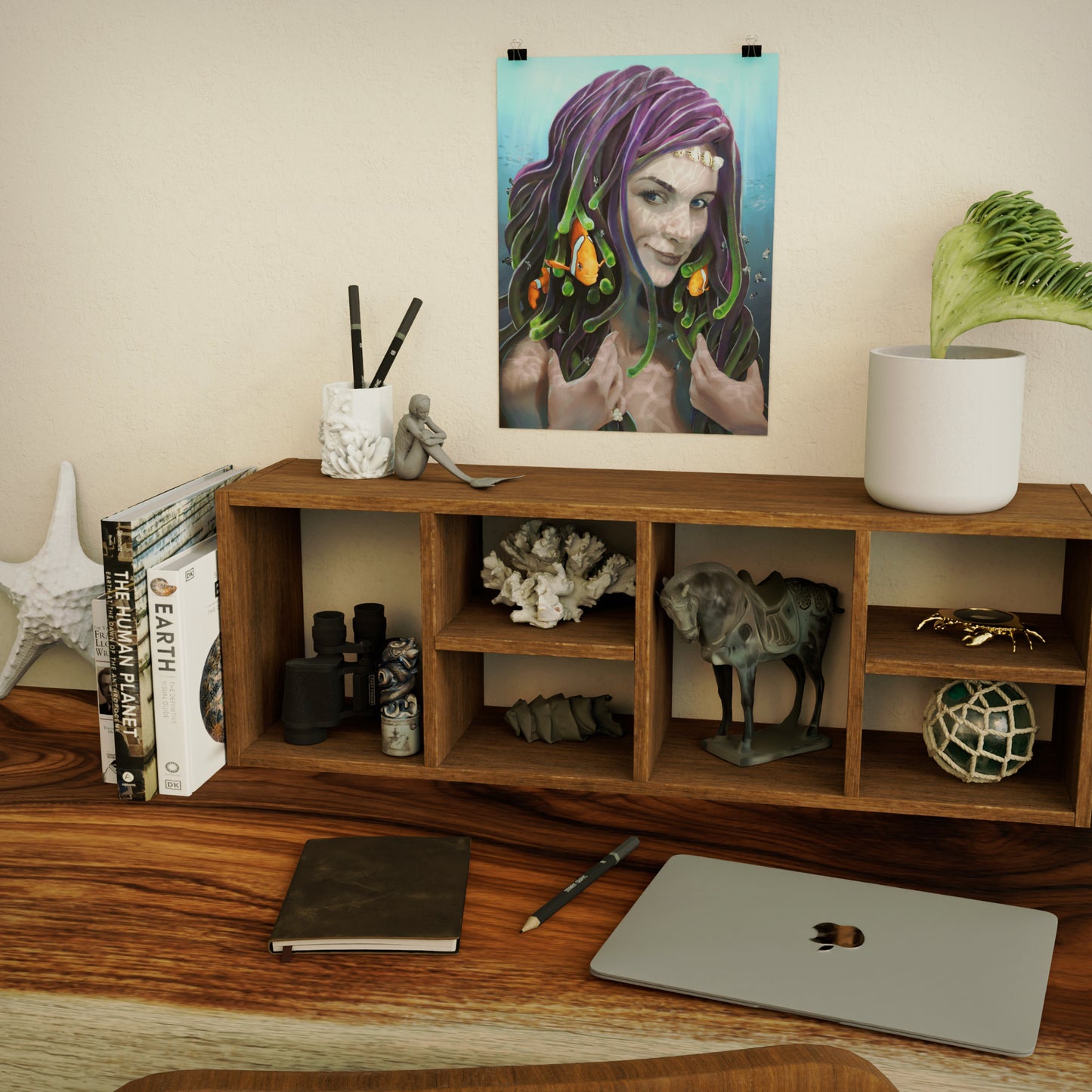 art print of anemone mermaid with little clownfish swimming around in her hair, posted above a wooden desk with ocean-themed decorative items