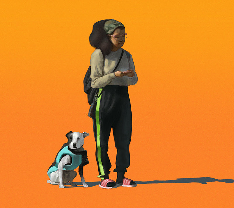 girl waits at the corner with her dog while looking at her phone