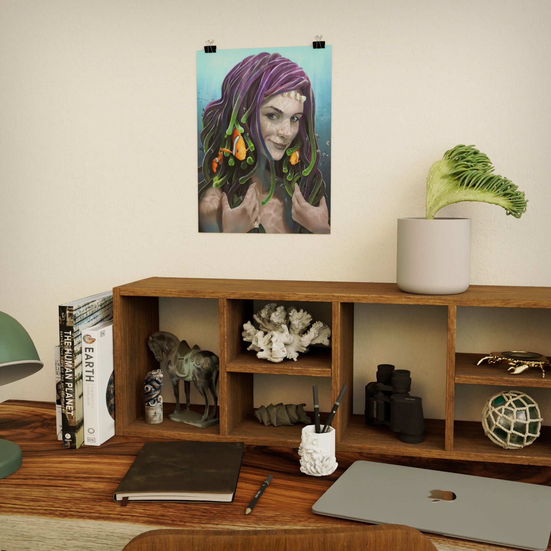 art print of anemone mermaid with little clownfish swimming around in her hair, posted above a wooden desk with ocean-themed decorative items